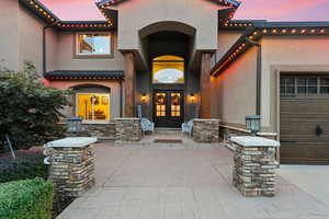 Exterior entry at dusk with french doors and a garage