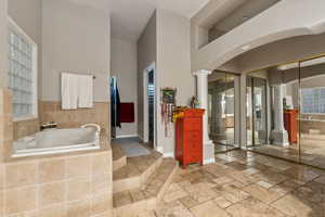 Primary Bathroom with tiled tub and ornate columns