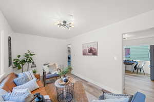 Living room with light hardwood / wood-style flooring and an inviting chandelier