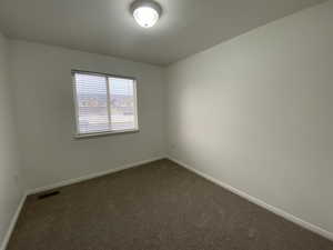 Unfurnished room featuring dark carpet