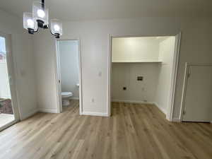 Interior space with light hardwood / wood-style flooring and an inviting chandelier