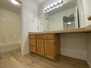 Full bathroom featuring washtub / shower combination, wood-type flooring, toilet, and vanity