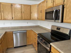 Kitchen featuring stainless steel appliances and light hardwood / wood-style floors