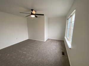 Carpeted empty room with ceiling fan