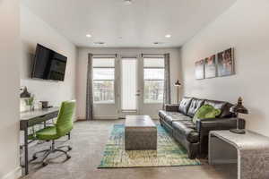 Living room with a textured ceiling and light colored carpet