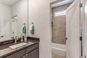 Bathroom featuring tiled shower / bath and vanity