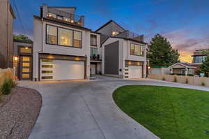 Modern home with a yard, a garage, and a balcony