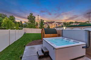 Exterior space with a yard and a hot tub