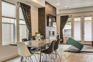 Tiled dining space with a tile fireplace and french doors