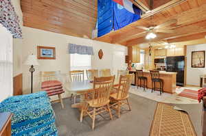 Tiled dining room featuring wooden ceiling, beamed ceiling, sink, and ceiling fan