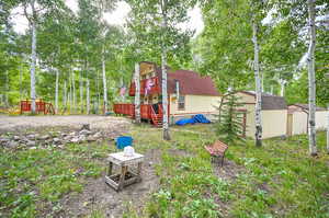 View of yard with a wooden deck and a storage unit