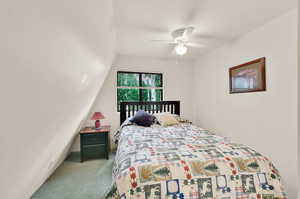 Bedroom featuring ceiling fan, carpet, and vaulted ceiling