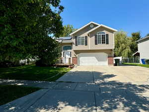 View of front of property with a garage and a front lawn