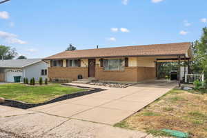 Single story home with a garage, a carport, and a front lawn