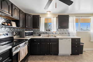 Kitchen with dishwasher, sink, stainless steel range, ceiling fan, and decorative backsplash