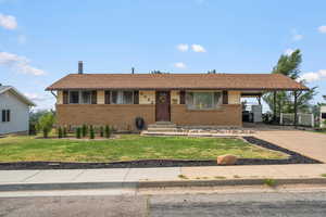 Single story home with a carport and a front lawn