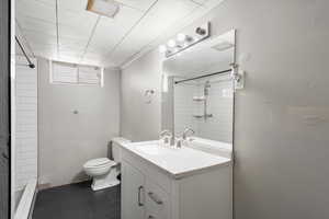 Bathroom with vanity, toilet, and a tile shower