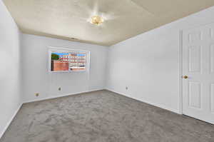 Unfurnished room with a textured ceiling and brand new carpet floors