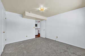 Carpeted empty room featuring a textured ceiling