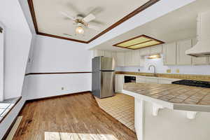 Kitchen dining with hardwood, ceiling fan, and bay window