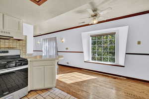 Dining area with hardwood, bay window, and ceiling fan