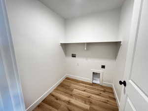 Laundry room with hookup for a washing machine, light wood-type flooring, and hookup for an electric dryer