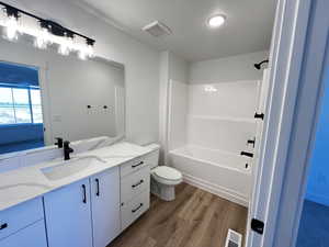 Full bathroom featuring bathing tub / shower combination, vanity, toilet, and wood-type flooring