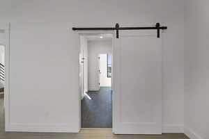 Hall featuring a barn door and tile patterned flooring