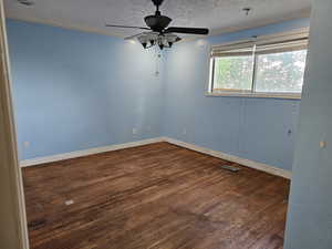 Unfurnished room featuring wood-type flooring, a textured ceiling, and ceiling fan