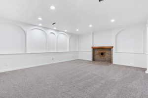 Unfurnished living room featuring a brick fireplace and carpet floors