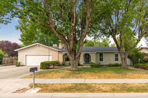 Single story home featuring a garage and a front lawn