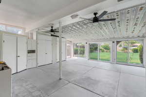 Unfurnished sunroom featuring ceiling fan