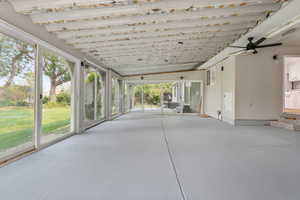 Unfurnished sunroom featuring lofted ceiling and a healthy amount of sunlight