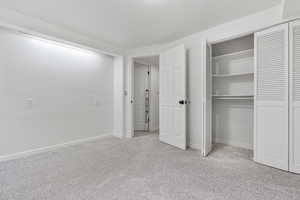 Unfurnished bedroom with a closet and light carpet