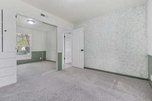 Unfurnished bedroom with light colored carpet and a closet