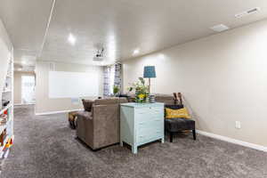 Carpeted living room with a textured ceiling