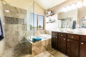 Bathroom featuring vanity, vaulted ceiling, and separate shower and tub. Radiant heat floor and dual sinks.