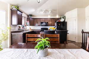 Kitchen featuring a textured ceiling, tasteful backsplash, black appliances, sink, and dark brown cabinetry