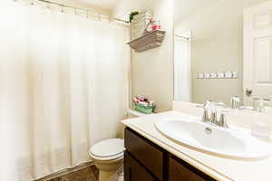 Bathroom featuring walk in shower, toilet, and vanity