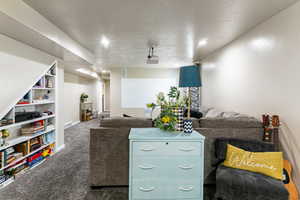 Living room featuring carpet flooring and a textured ceiling