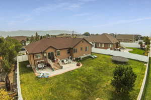 Back of house with a yard and a patio