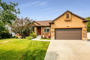 View of front of property featuring a front lawn and a garage