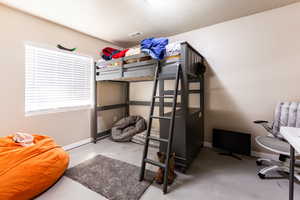 Bedroom featuring concrete floors and a textured ceiling