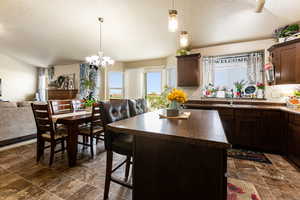 Kitchen featuring a center island, a textured ceiling, backsplash, and sink