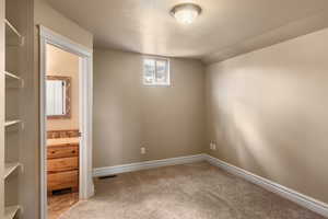 Unfurnished room with lofted ceiling and carpet flooring