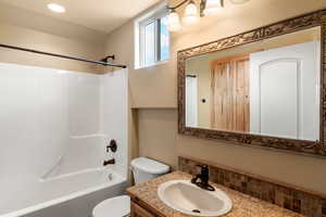 Full bathroom featuring toilet, bathing tub / shower combination, and vanity