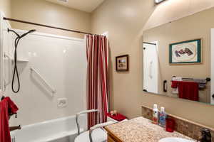 Full bathroom featuring toilet, shower / tub combo with curtain, and vanity