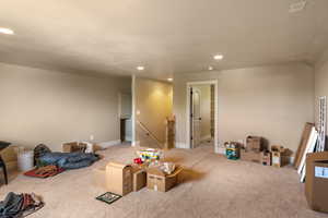 Recreation room featuring light carpet and vaulted ceiling