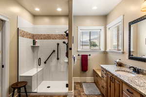 Bathroom featuring vanity and a shower with door