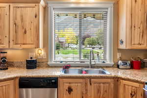 Kitchen with dishwasher, a healthy amount of sunlight, sink, and light brown cabinets